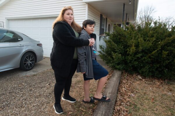 Brandy Carlson stands in yard with son, Michael