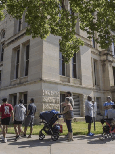A long line of voters wraps around the Sedgwick County Historic Courthouse in Wichita, Kan., on the last day of early voting on Aug. 1, 2022. Kansas' top elections official warned voters Monday, Oct. 31, 2022, that text messages they were receiving could