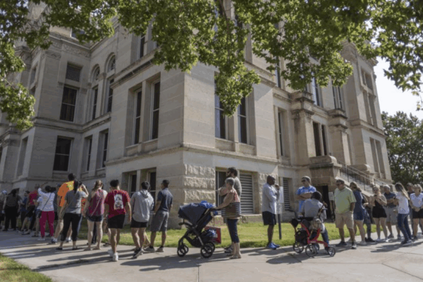 A long line of voters wraps around the Sedgwick County Historic Courthouse in Wichita, Kan., on the last day of early voting on Aug. 1, 2022. Kansas' top elections official warned voters Monday, Oct. 31, 2022, that text messages they were receiving could