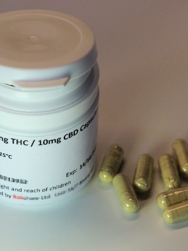 Container labeled as THC with pills sitting near it.