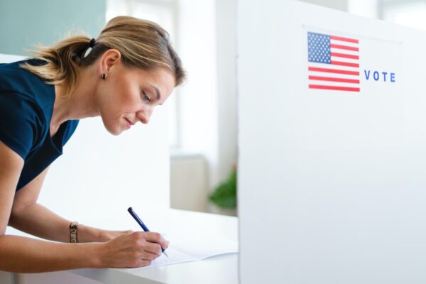 Woman filling out a ballot at a voting booth