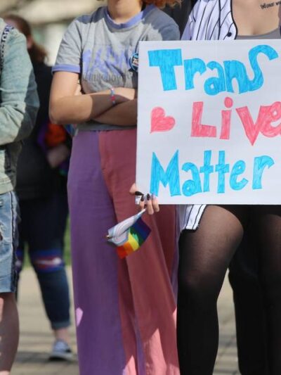 protestors with sign that says trans lives matter