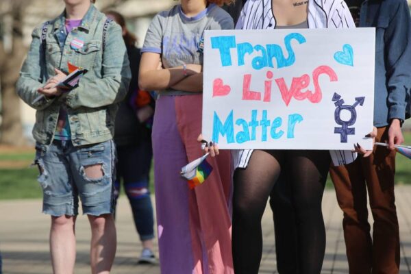protestors with sign that says trans lives matter