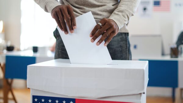 Man putting ballot into ballot box