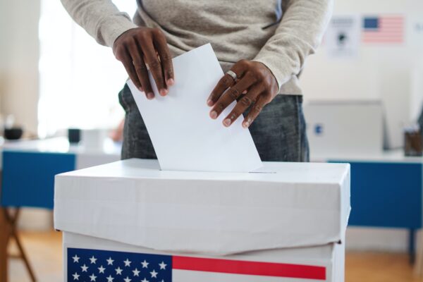 Man putting ballot into ballot box