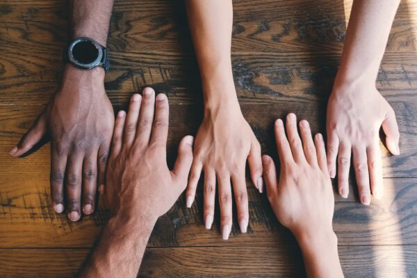People with their hands together on a table