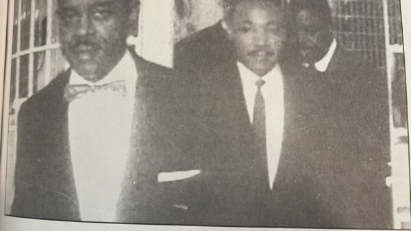 Black and white image from newspaper, caption reads: Attorney Hollowell escorts Dr. Martin Luther King, Jr. «as Rev. Ralph D. Abernathy from the Reidsville State Prison in 1960