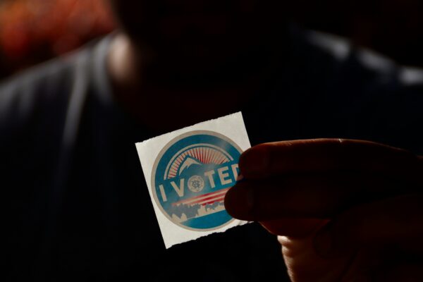 Person holding "i vote" sticker