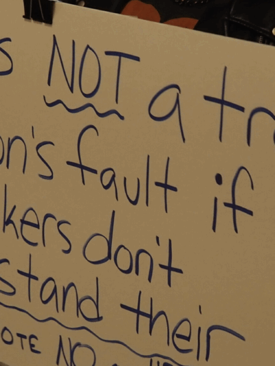 Activist Jae Moyer holds up a sign protesting new legislation that would restrict access to gender-affirming care in the state. (Rachel Mipro/Kansas Reflector)