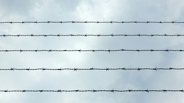 Barbed wire in front of blue sky