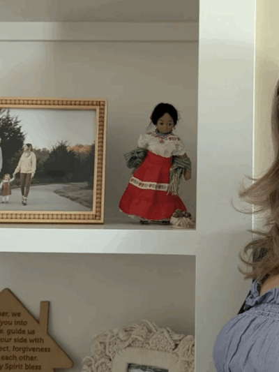 Cindy Phillips stands by a shelf filled with family photos and Mexican-themed dolls. "Its a daily reminder of my heritage for me and my daughter," she said. Lawrence Brooks IV/KCUR 89.3