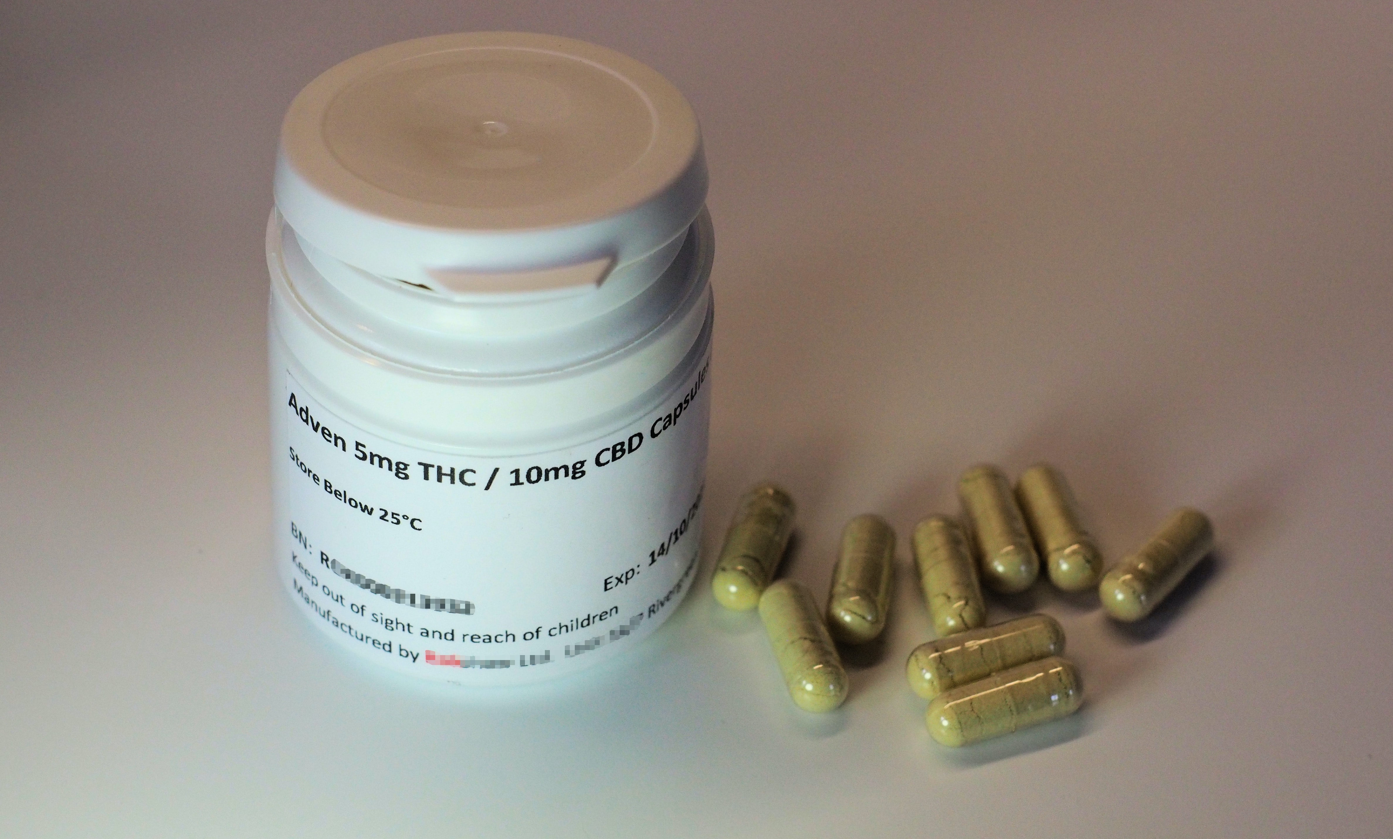 Container labeled as THC with pills sitting near it.