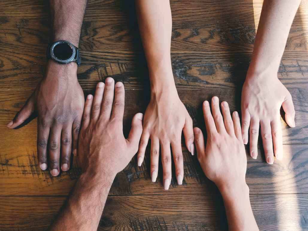 People with their hands together on a table