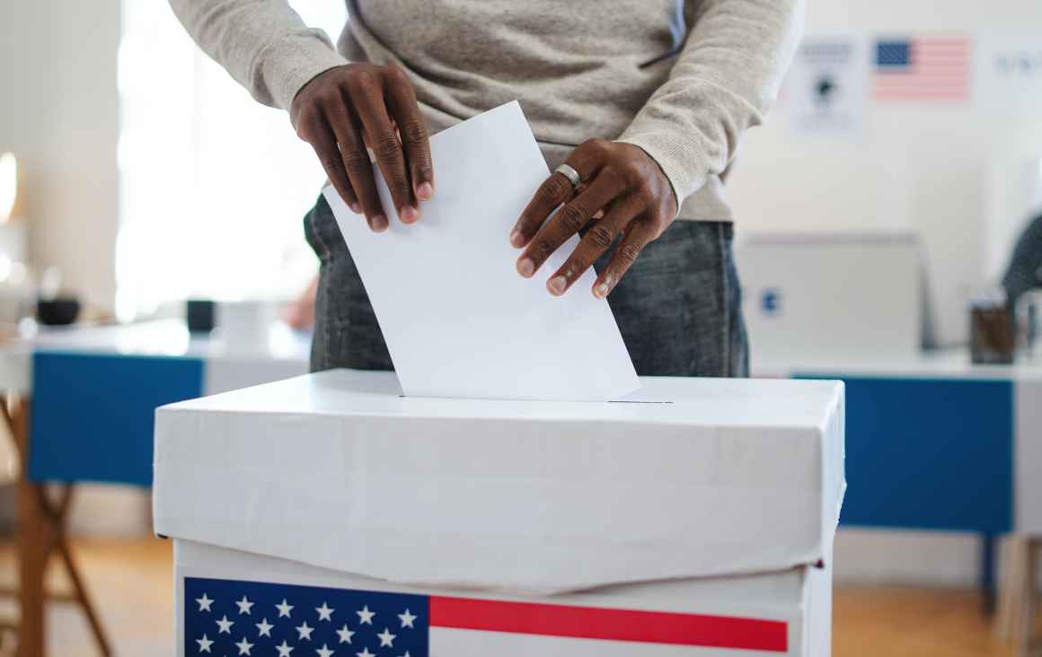 Man putting ballot into ballot box