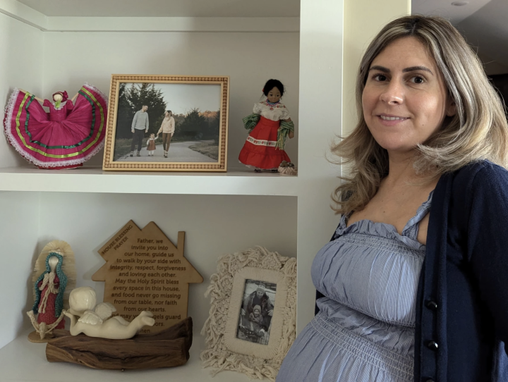 Lawrence Brooks IV / KCUR 89.3 Cindy Phillips stands by a shelf filled with family photos and Mexican-themed dolls she brings back to Kearney, Missouri, when she travels back to Mexico. "Its a daily reminder of my heritage for me and my daughter."