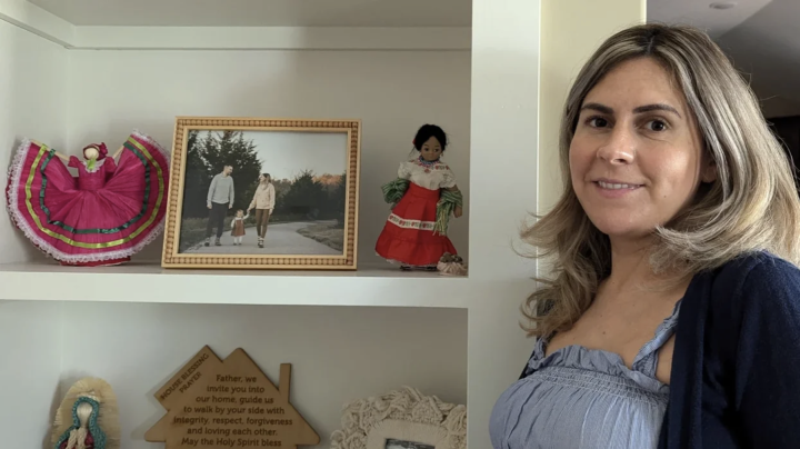 Cindy Phillips stands by a shelf filled with family photos and Mexican-themed dolls. "Its a daily reminder of my heritage for me and my daughter," she said. Lawrence Brooks IV/KCUR 89.3