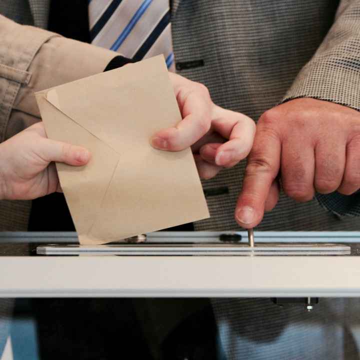 Putting ballot into ballot box