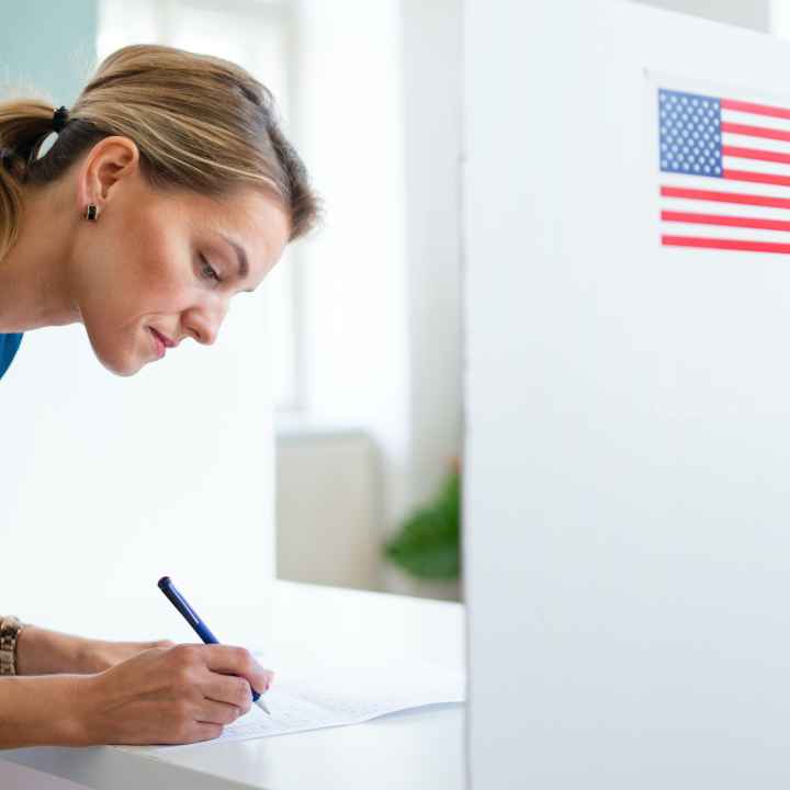 Woman filling out a ballot at a voting booth
